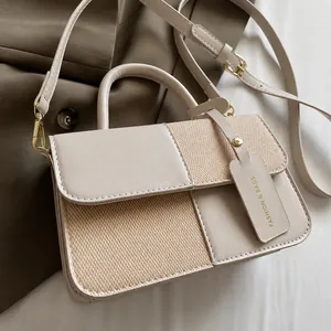 Close-up of beige and brown contrast handbag featuring textured woven panel and leather
