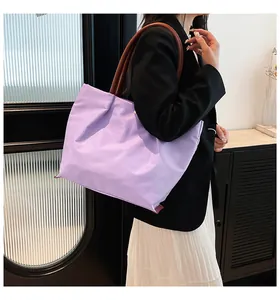 Lavender nylon tote bag shown in a stylish fashion outfit with soft lighting