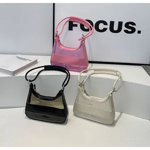 Detalle de bolsos jelly semitransparentes en PVC de colores rosa, negro y beige actual