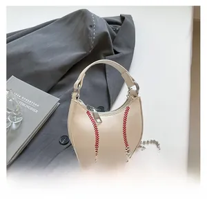 Close-up of a creamy white mini dumpling bag with red baseball stitching and chain strap