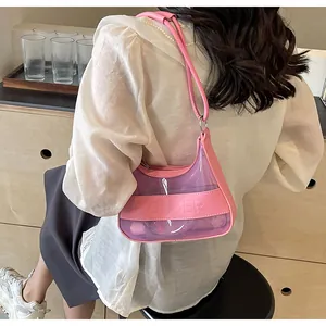 Detalle de bolso de hombro en PVC rosa transparente con cremallera y asa de cuero