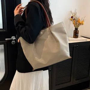 Minimalist beige nylon tote bag with brown leather handles for women's daily commute