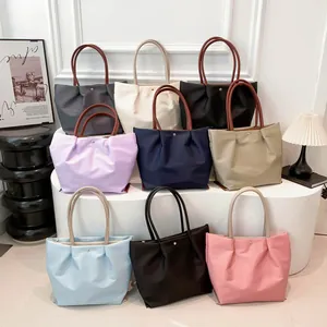 Waterproof nylon tote bags in nine colors with brown handles and pleated design details