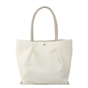 Minimalist waterproof nylon tote bag in cream white with brown leather handles