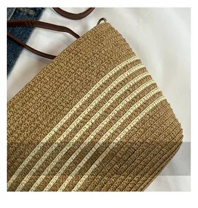 Détails de sac en paille tressée kaki montrant la texture fine et la sangle en cuir
