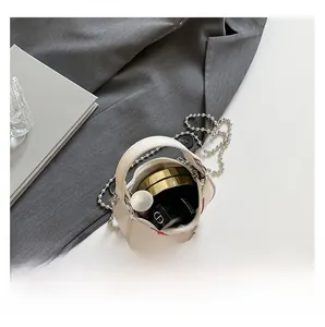 Macro view of white mini handbag interior showing space for makeup and silver chain strap