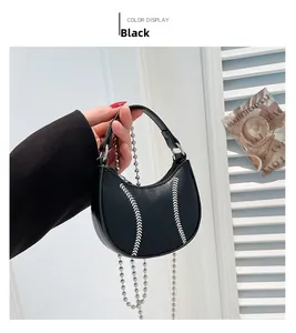 Detail of black mini dumpling bag with silver stitching and bead chain held by model
