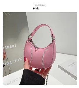 Detail of pink hobo mini bag showing silver baseball stitching and metal chain strap