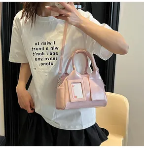 Pale pink glossy pillow bag featuring a clear card slot and adjustable strap detail
