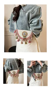 Close-up of Bohemian woven bag with ethnic embroidery, colorful beads and fringe details