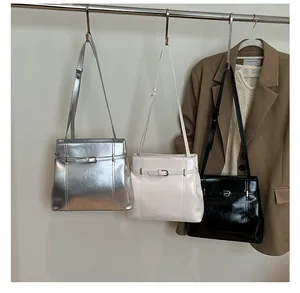 Tres bolsos de hombro minimalistas de cuero PU en plata, blanco roto y negro con una chaqueta