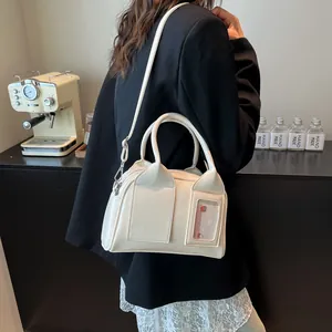 Cream white leather bowling bag with a transparent card slot and detachable strap