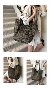 Detail view of large leopard print tote bag with vintage metal logo and shoulder straps