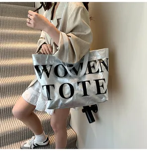 Dettaglio della trama della borsa tote argento metallizzato e grande stampa di lettere