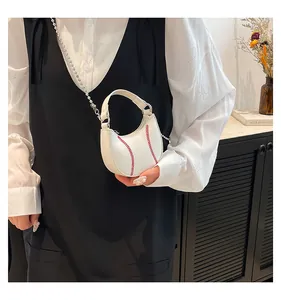 Mini white baseball-stitched crossbody bag with silver chain strap worn by a model