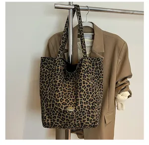 Detail of leopard print tote bag featuring a metallic handmade label on canvas fabric
