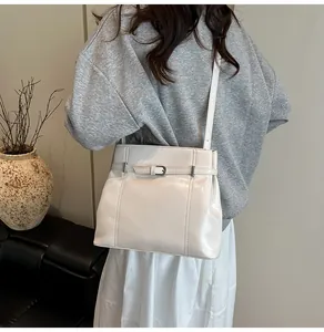 Bolso bandolera blanco de cuero PU con hebilla plateada mostrado en una modelo