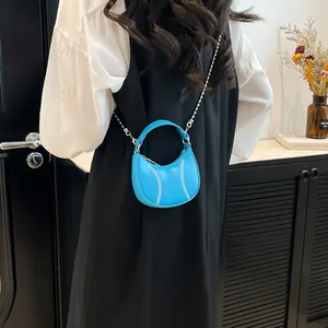 Mini bright blue leather dumpling bag with white baseball stitching and pearl chain strap