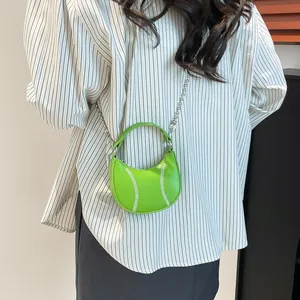 Neon green mini tennis ball handbag with silver chain strap shown on model