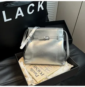 Detalle de bolso cubo plateado metalizado en una elegante caja de regalo negra