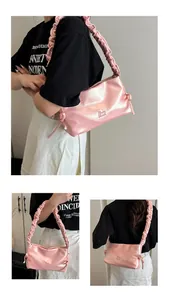 Dettaglio borsa a spalla rosa metallizzata con tracolla increspata e logo Moon Shark