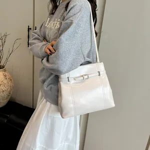 Bolso saco minimalista de cuero PU crema con hebilla decorativa y correa delgada