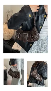 Detail of coffee vintage leather underarm bag with pleated texture and silver buckle