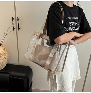 Close-up of a large transparent PVC tote bag with a beige inner pouch and woven straps