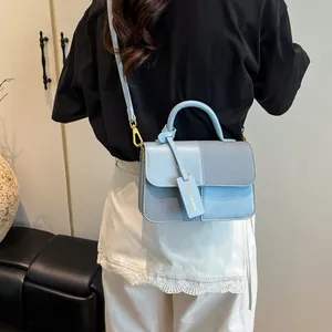 Elegante borsa a tracolla celeste con inserto in tessuto a spina di pesce e dettagli oro