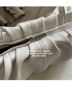 Nahaufnahme des glatten Silber-Metallreißverschlusses und weißem Leder im Faltendesign