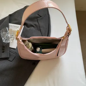 Sac hobo en cuir verni rose pâle avec détails dorés montrant le rangement intérieur