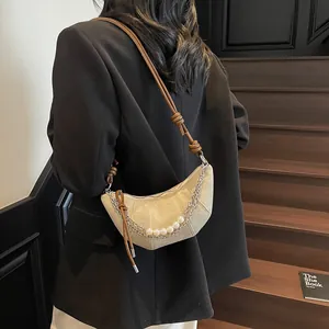 Sac croissant beige avec chaîne perlée et bandoulière à nœuds, vue arrière élégante