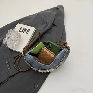 Sac croissant en denim bleu avec bandoulière en cuir marron et chaîne de perles chic