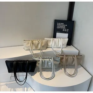 Detailansicht der Cloud-Schultertaschen in fünf Farben auf minimalistischen Ständern