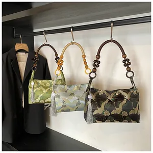 Detail of embroidered satin handbags with wooden handles and crane patterns