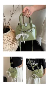 Détail du sac coquillage vert clair avec nœud de perles élégant et texture en cuir