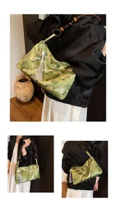 Detail of green brocade handbag featuring crane patterns, wooden bead handles, and silk tassels