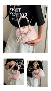 Détail du sac rose clair avec nœud en dentelle blanche et pendentif en perles