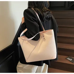 Detail of light pink tote bag featuring woven texture and gold rivets on a black blazer