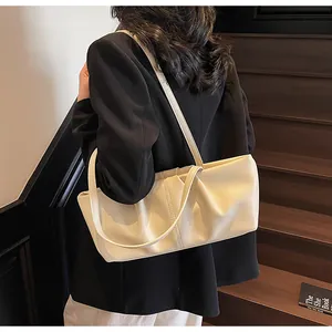 Detail der cremefarbenen Schultertasche mit Falten-Design und doppelten Trägern