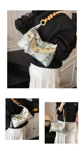 Detail of light blue jacquard shoulder bag with crane patterns and wooden bead handle
