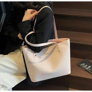 Detailed woven texture of this light pink tote bag worn on shoulder by a model