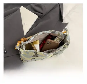 Internal view of blue embroidered bag showing capacity for phone, perfume and lipstick
