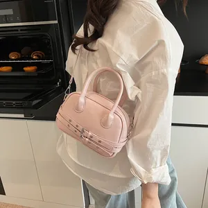 Petit sac carré rose minimaliste avec doubles poignées et détails de boucles en métal