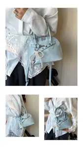 Vue détaillée du sac coquille bleu clair avec double fermeture et pendentif perle