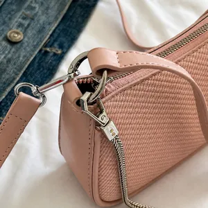 Close-up of pink woven texture handbag featuring premium silver metal hardware and chain