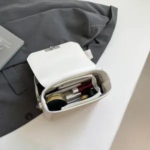 Minimalist cream white crossbody bag with organized interior compartments shown from top view