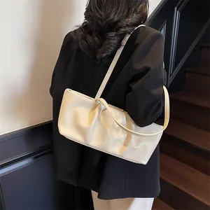 Minimalistische beige Leder-Einkaufstasche mit Falten, am Modell auf der Treppe