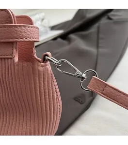 Detail of pink lychee grain leather handbag featuring silver metal hardware and pleated texture