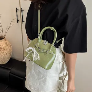 Sac à bandoulière vert avocat avec pendentif nœud perlé et détail de cœur métallique